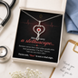 White gift box with stethoscope heart necklace, nurse message card, scrubs and thank-you note