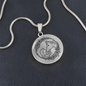 Close-up of girl and horse engraved heart pendant in surgical steel
