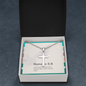 Close-up of minimalist stainless steel cross pendant on ball chain