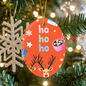Holiday ornament with playful reindeer and festive lettering