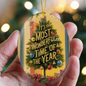 Close-up of glossy oval holiday ornament with festive gold cord