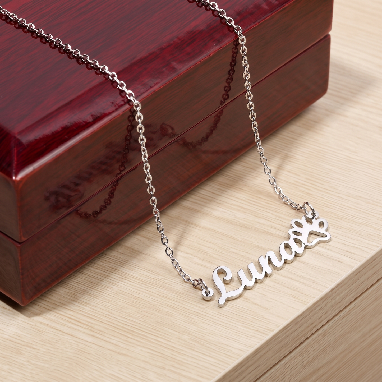 Silver name necklace with 'Luna' on a wooden surface