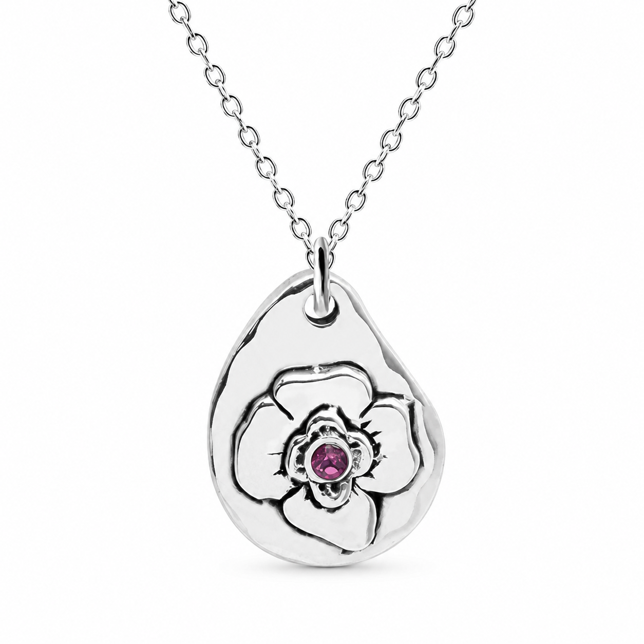 A sterling silver teardrop pendant necklace featuring a stylized flower design with a small round pink gemstone at the center, suspended from a delicate silver chain against a white background.