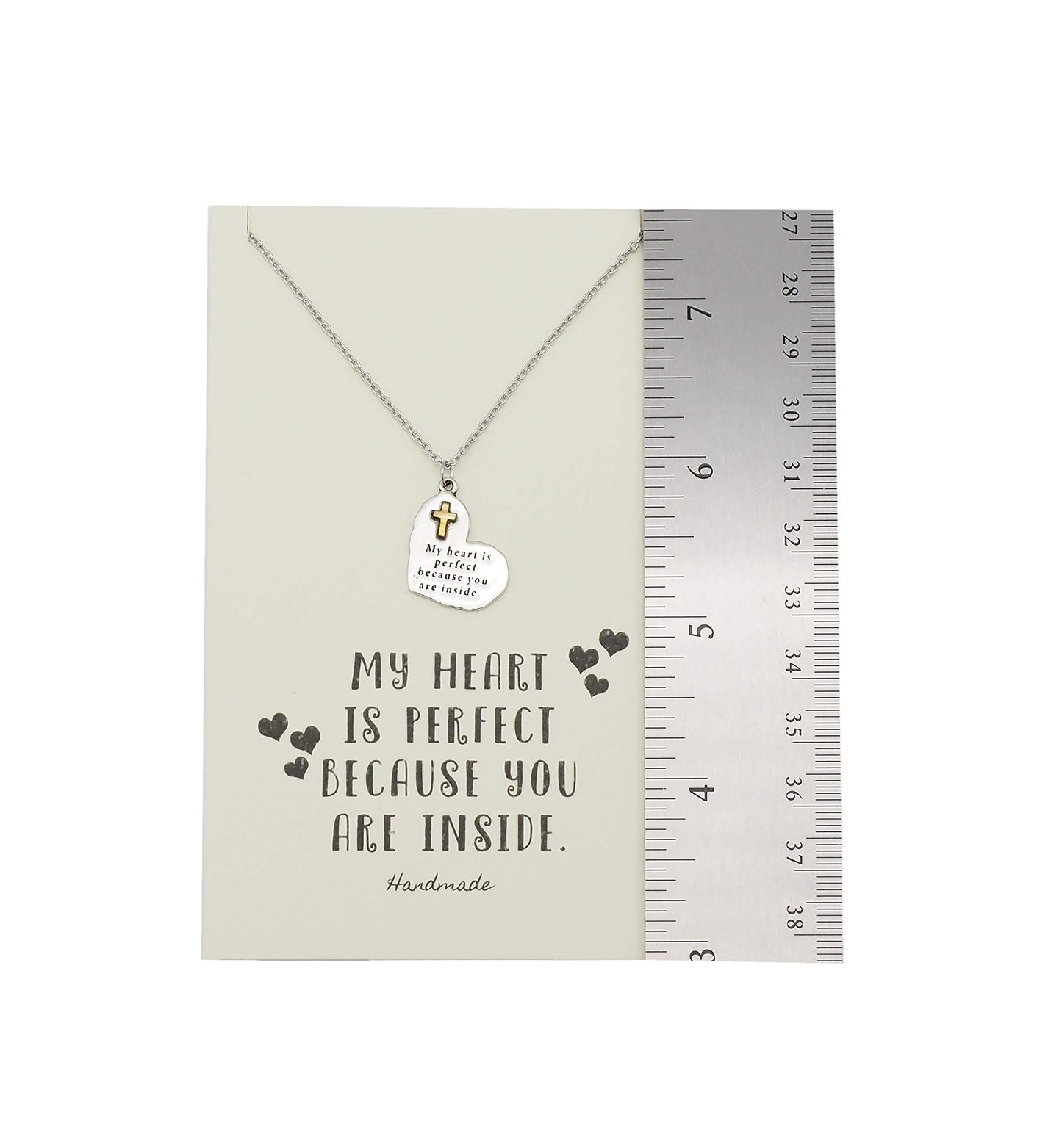 Necklace with a heart pendant on a card with text, next to a ruler for size reference.