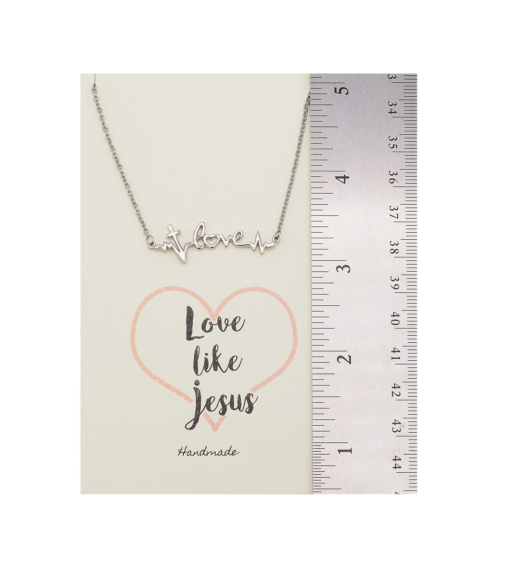 Necklace with 'love like Jesus' message on a card with a ruler for scale.