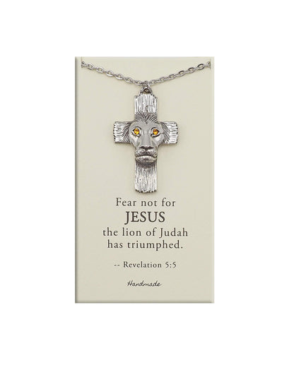 Silver cross necklace with lion head design on a beige card with text, on a white background
