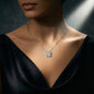 Silver necklace with a floral pendant on a dark background