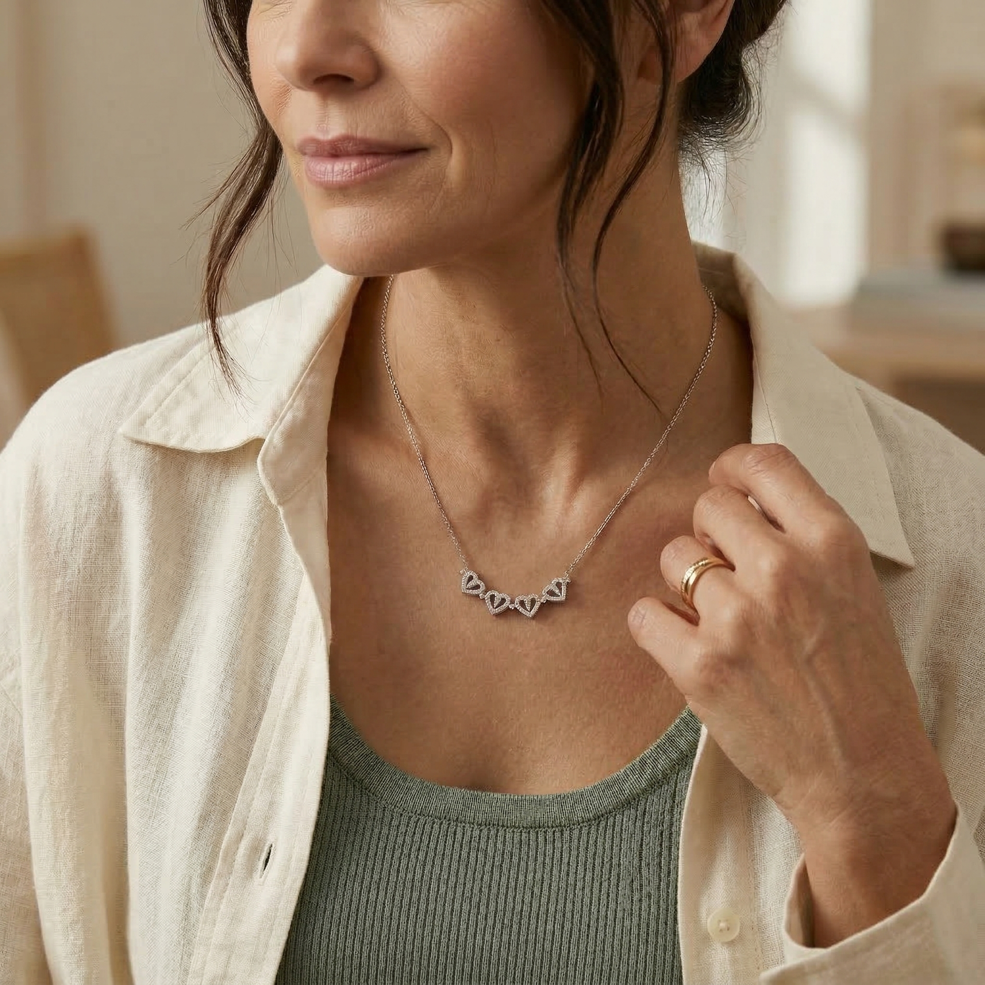 Woman wearing a necklace with a blurred indoor background