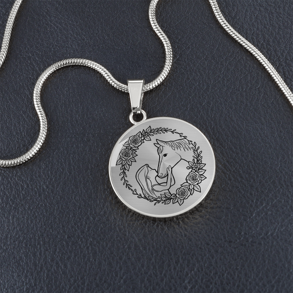 Close-up of girl and horse engraved heart pendant in surgical steel