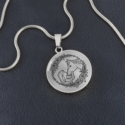 Close-up of girl and horse engraved heart pendant in surgical steel