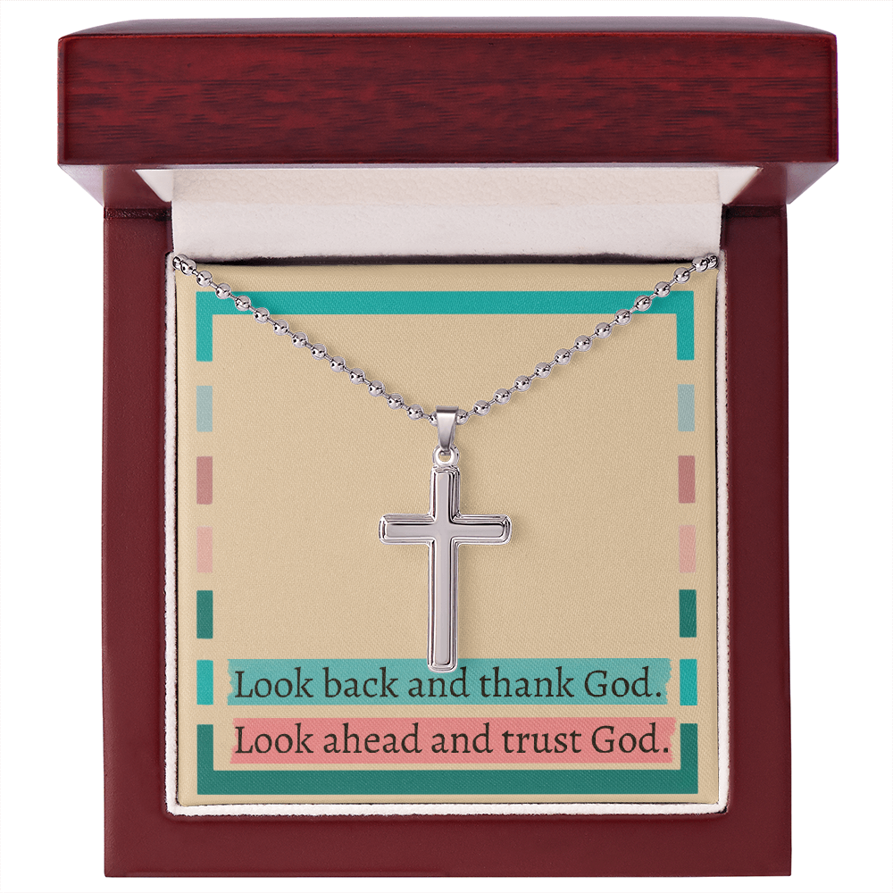Close-up of engraved cross pendant symbolizing divine trust