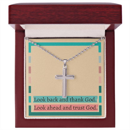 Close-up of engraved cross pendant symbolizing divine trust