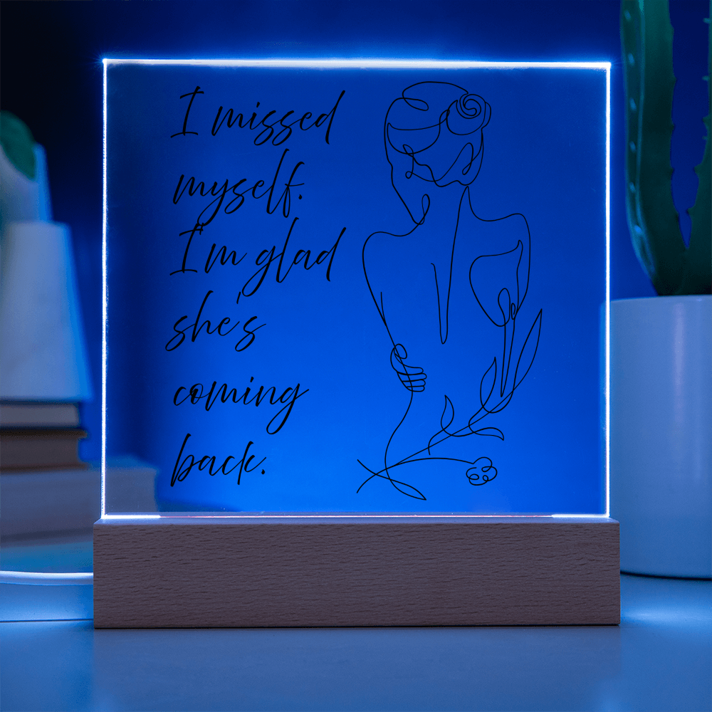 Minimalist acrylic quote frame glowing softly on nightstand