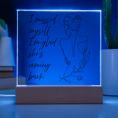 Minimalist acrylic quote frame glowing softly on nightstand