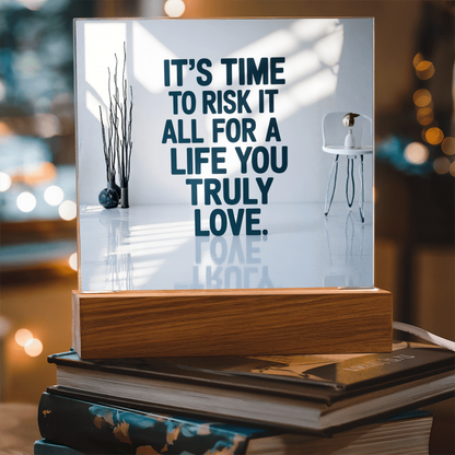 Motivational acrylic plaque displayed on desk beside notebook and candle for inspiration.