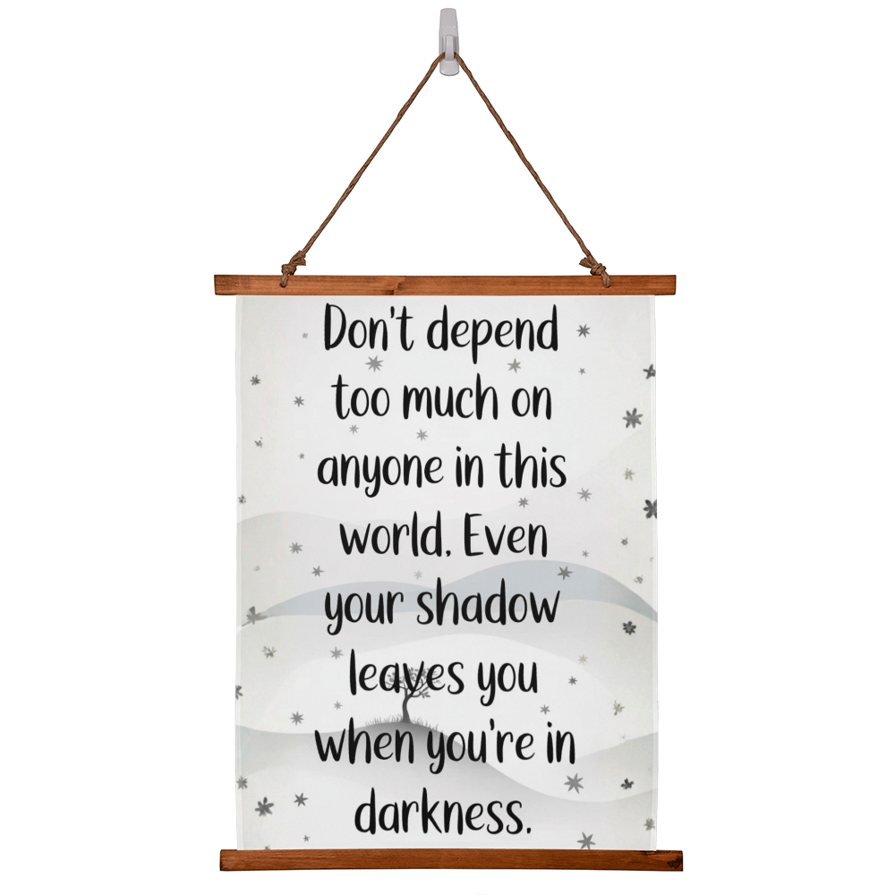Wood framed quote tapestry reading ‘Don’t depend too much on anyone…’ hanging on wall