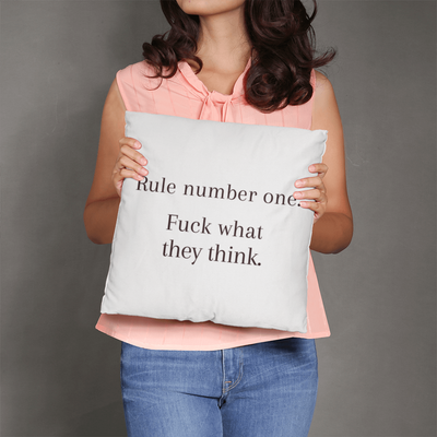 Empowering pillow styled on couch with cozy throw and candles for modern home decor.