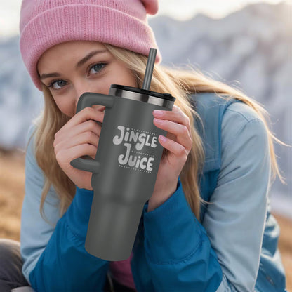 Flat lay of engraved Christmas tumbler with ornaments and greenery
