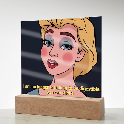 Motivational acrylic plaque displayed on minimalist bookshelf beside plants and framed art.