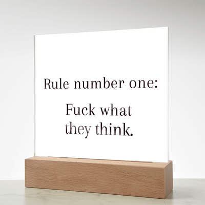 “Rule Number One: F*ck What They Think” quote plaque displayed on vanity beside perfume and jewelry for fearless feminine energy.