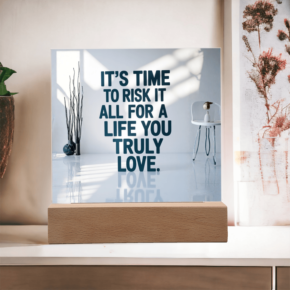 Acrylic motivational light plaque on shelf next to books about success and personal growth.