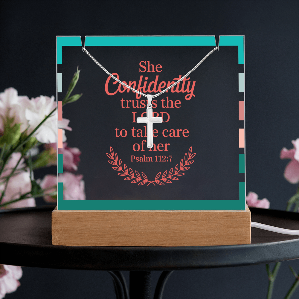 Christian keepsake and necklace styled on wooden table with Bible and candlelight.