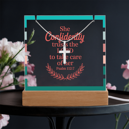 Christian keepsake and necklace styled on wooden table with Bible and candlelight.