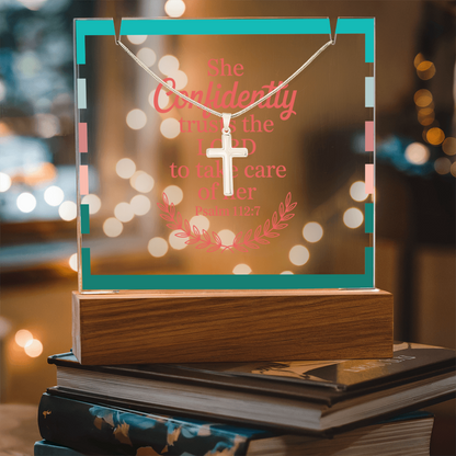 Christian gift set with cross necklace displayed next to floral arrangement and prayer book.