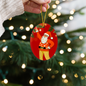 Close-up of Santa ornament with golden stars and wrapped gifts