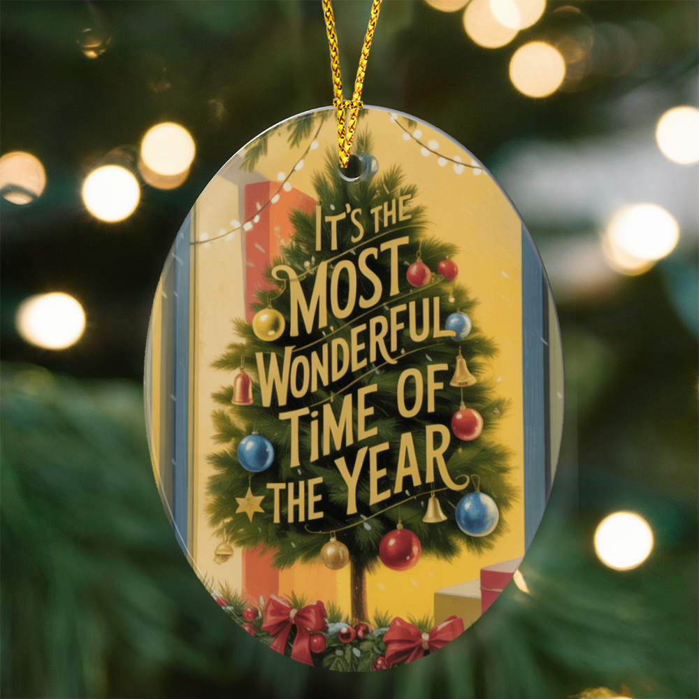 Flat lay of “It’s the Most Wonderful Time of the Year” ornament beside pine and lights