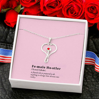 Close-up of polished stainless steel stethoscope pendant featuring red Swarovski crystal detail.