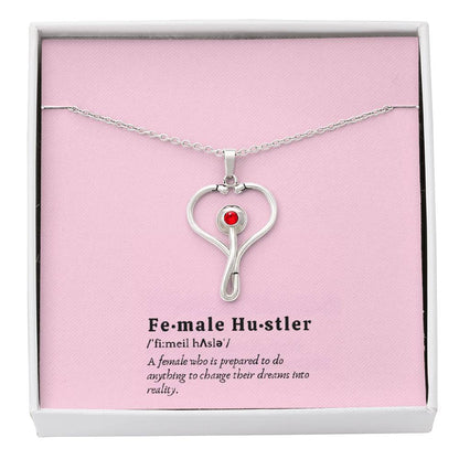 Female Hustler stethoscope necklace with heart-shaped pendant and red Swarovski crystal.