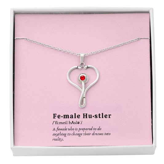 Female Hustler stethoscope necklace with heart-shaped pendant and red Swarovski crystal.