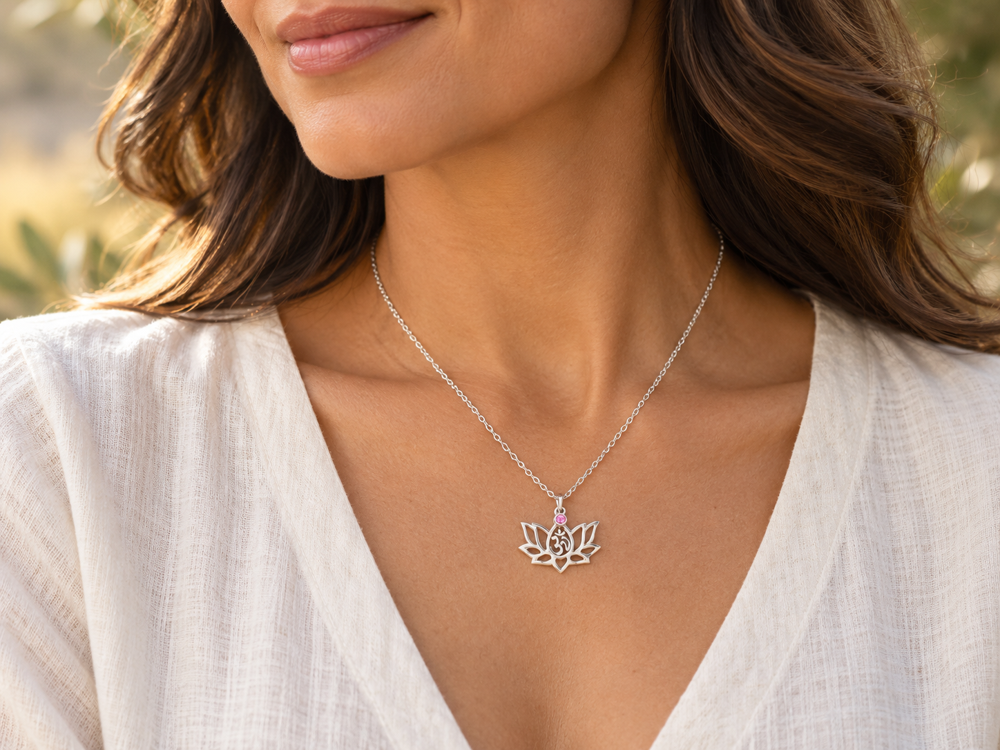 Woman wearing the silver October lotus necklace with a pink birthstone